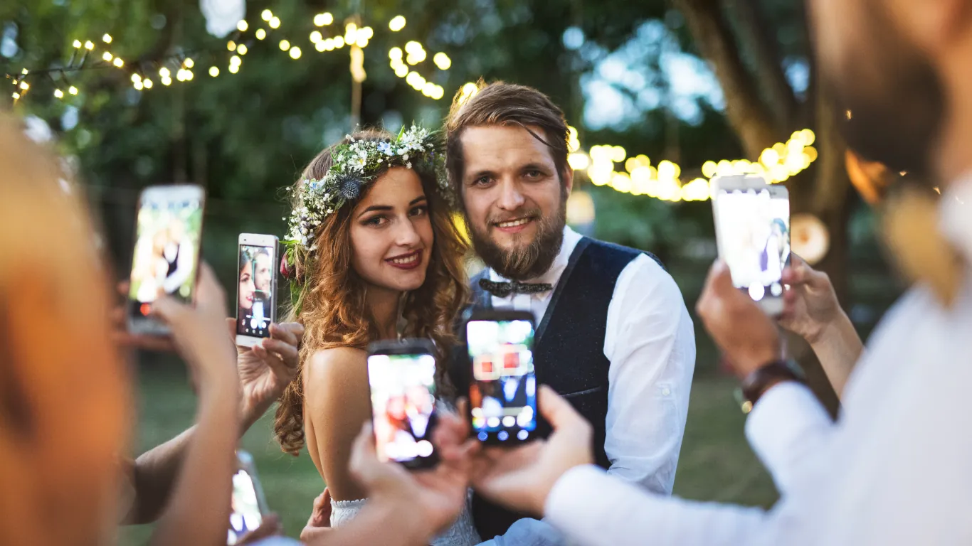Guests take pictures of the happy bride and groom on their wedding day